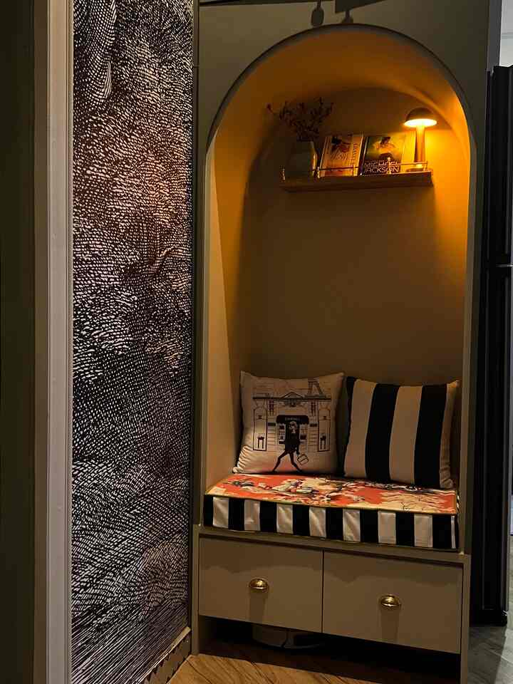 Cozy natural color corner nook featuring built-in storage bench with gold accents and warm wall lighting