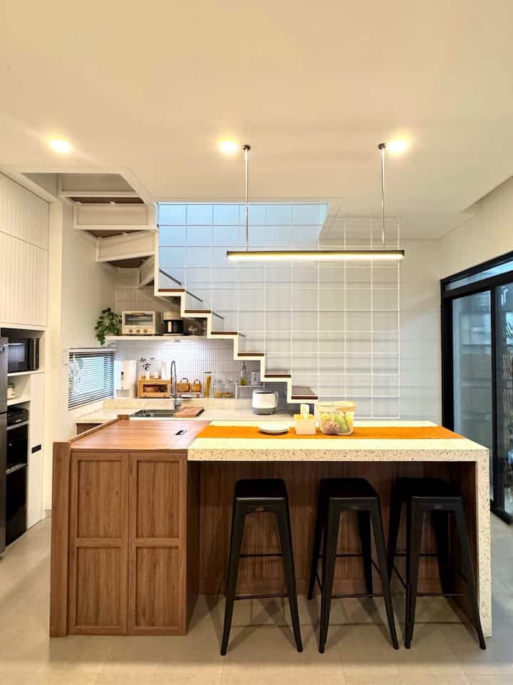 Kami menyepakati konsep open plan pada area dapur dan area ruang keluarga, tujuannya ingin ruangan terlihat lebih luas dan tetap terconnect dengan anak-anak ketika kita sedang berada di area dapur.

Karena letak dapur kami dibawah tangga maka tidak banyak ruang untuk menambahkan tempat penyimpanan. Kami mendesain kabinet-kabinet di kitchen set untuk menyimpan berbagai peralatan makan, masak, dan perbumbuan.

Meja island pun kami satukan dengan meja kompor dan kami  buat sistem pocket door agar bisa ditutup ketika kami membutuhkan meja yg lebih luas.

#kitchenset #kitchensetminimalis #kitchensetbawahtangga #mejaisland #terrazzo #kitchenopenplan #peralatanmakan  #InspirasiRuangMakan #Dapurminimalis #lampugantung 