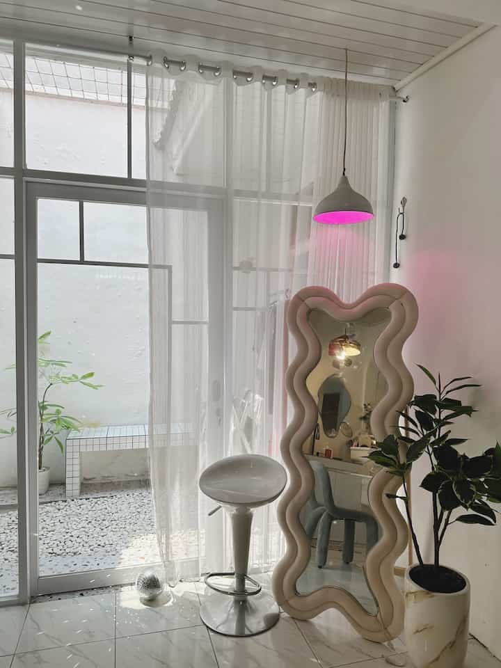 Rumah Mininalis Modern. Ini mengusung konsep modern minimalis dan berjiwa muda. Meskipun terkesan sederhana tetapi setiap ruangan terlihat unik dan berbeda pada umumnya. 

Sudut ruang minimalis.
Standing Mirror Curvy ini terlihat anggun dan cantik di pojok ruang, ditambah dekorasi pohon artificial karet kebo, pot tanah jumbo dan kursi bar. 
Terdapat pintu kaca sliding geser menuju teras rumah belakang memberi pencahayaan yang maksimal saat siang hari, vitrase gorden transparan sebagai penghalang supaya tidak silau. 
Diatasnya ditambah lampu gantung liontin minimalis sebagai pemanis. 
Tambahan hiasan bola disco untuk permainan cahaya. 

Musholla rumah 
Musholla yang nyaman untuk beribadah. Dengan dekorasi lucu dan lampu-lampu yang menggemaskan, karpet estetik juga sebagai alas sajadah. Nakas bulat untuk menyimpan mukena supaya rapi, juga rak brosur yang digunakan sebagai rak buku dan Al-Qurʼan. 
Dinding Musholla diberi sentuhan keramik precut mozaik unik sekali. 

Pojok ruang antara kamar mandi dan kamar studio. 
Disini supaya tidak kelihatan sepi dindingnya dipasang frame estetik, juga kursi estetik model keju. Depan kamar studio ada keset lucu unik berbentuk tv. 
Depan kamar studio ada sofa, terlihat bantal unik berbentuk arch dan blanket selimut sofa. 
Pintu kusen kamar kami masih bentuk klasik sebagai bawaan rumah aslinya. Untuk cat pintu sementara berwarna coklat netral. 

Service Area 
Laundry room dirumah kami juga mengusung konsep minimalis. Area ini terdapat diluar di teras belakang rumah dan open space. Jadi kami butuh gorden mini (poster kain) sebagai penutup mesin cuci supaya tidak kena hujan. Diatas mesin cuci kami tambahkan rak serbaguna juga troli susun di samping untuk menyimpan alat sabun. 
Roster pada landry room ini sebagai penghalang menutupi pompa air dan gudang didalamnya (tempat sapu dll). Lantainya kami pilih motif terrazo cantik. 
#rumahminimalismodern #mushollarumah #pojokruangan #sudutruangrumah #laundryroom #servicearea #standingmirror #kursicafe #pohonartificial #gordervitrase #pintukacasliding #kursikeju #bantalsofa #selimutsofa #lampuestetik #karpetestetik #nakassusun #rakbuku #lampugantung #ohouseseason9 #ummaHaus #minimalismodern
