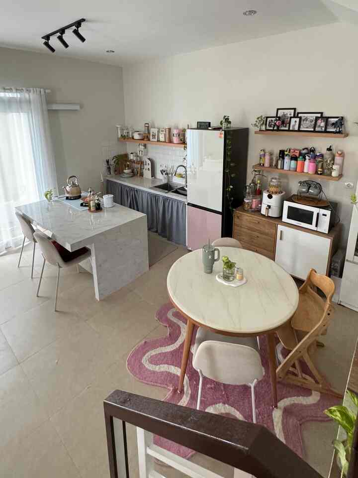Ivory walls and light gray lower kitchen cabinets in a minimal dining room featuring kitchen island and round dining table