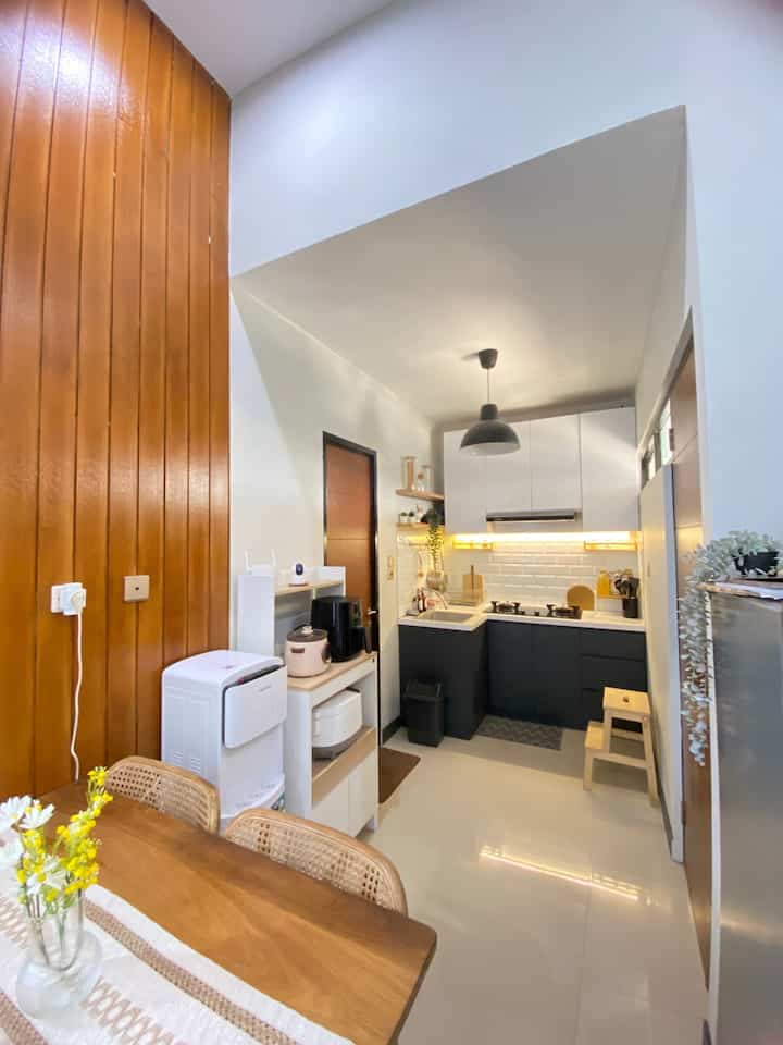 Modern kitchen in white and black tones with dining table featuring wood finish and Nordic style table runner, harmonious space