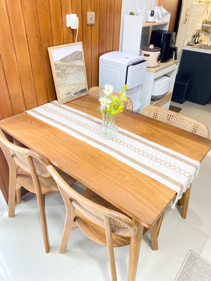 Wood tone and beige kitchen and dining area featuring a dining table with chairs in a cozy setting