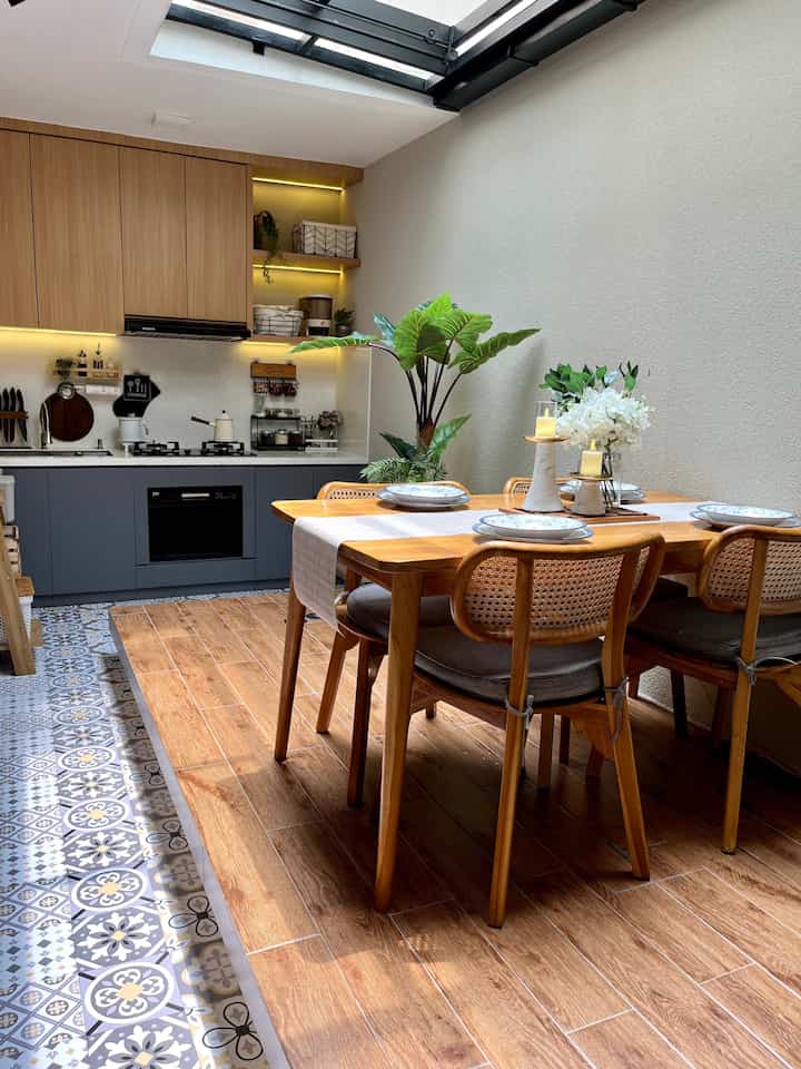 Natural wood tone and gray harmonized dining room and kitchen with clean, bright ambiance