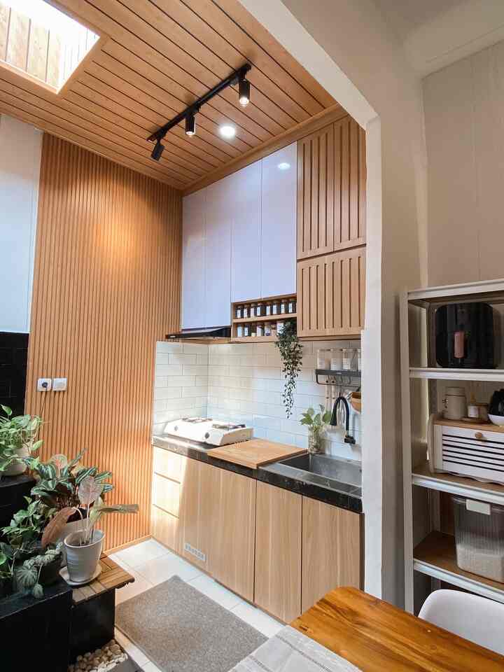Warm and simple Japandi-style kitchen and adjacent dining room featuring wood tones and white elements