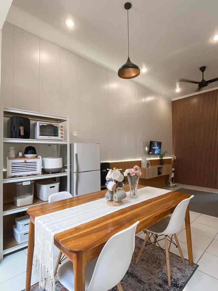 Natural dining room with white walls, brown wooden table, kitchen appliances, and organized storage unit
