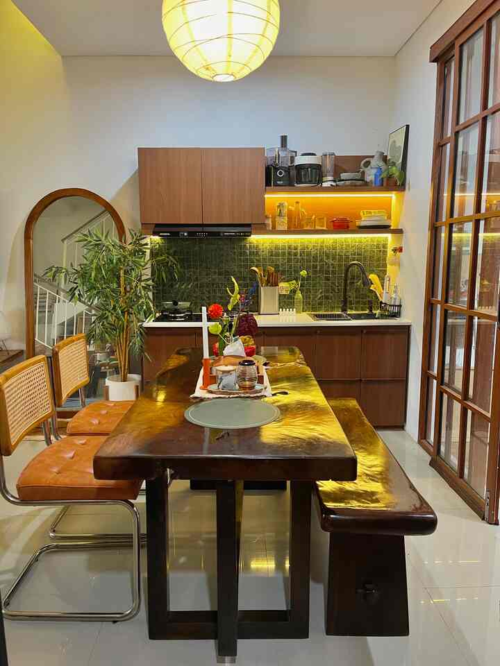 Warm brown tone dining room featuring a solid wood table and kitchen cabinetry with cozy natural atmosphere.