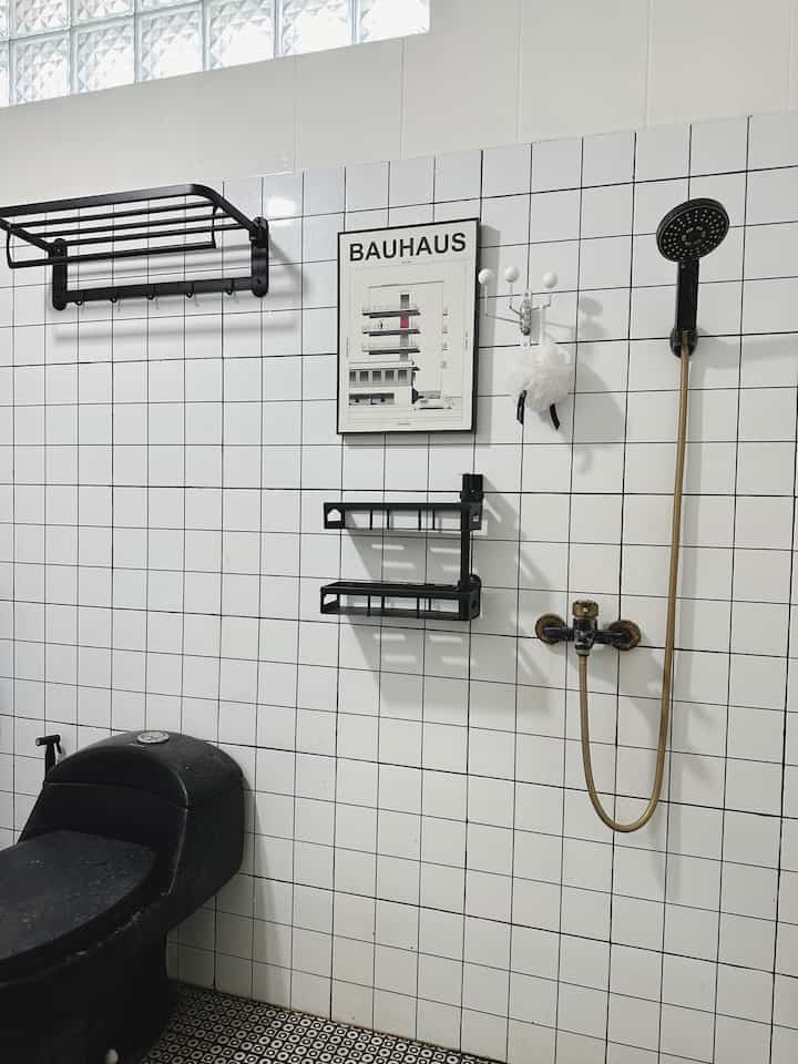 Kamar Mandi berkonsep monocrome. Luas 3 meter x 2 meter. Setelah renovasi, kamar mandi yang bernuansa putih hitam ini terkesan luas. 
Ornamen dekorasi berwarna hitam menjadikan kontras dengan warna dinding dan lantainya. 

Printilan estetik juga mewarnai kamar mandi ini, seperti rak botol sabun yang seharusnya adalah rak botol wine kami alih fungsikan. Tempat sampah dengan tutup warna putih, keset kaki estetik menambah cantik kamar mandi dan shower mandi model simpel saja. Rak handuk yang dapat dilipat. 

Kami memakain wastafel mini yang simpel dengan kran hitam senada. Terdapat juga cermin curvy estetik dengan lampu LED, kanan-kiri cermin ada hook tempel berwarna warni lebih ceria. Rak troli susun transparan beroda untuk peralatan mandi memudahkan untuk digeser. 

Pada pintu kamar mandi terbuat dari pvc sehingga lebih awet dan tahan air. Dinding kamar mandi memakai keramik mozaik precut hanya 2 meter dari lantai kamar mandi tetapi kami tempel seluruh sisi kamar mandi. Untuk lantai keramik kami pilih motif hitam dan putih. 
#kamarmandiminimalis #kamarmandimonocrome #shower #closet #hookgantung #frameposter #raksabundinding #rakhanduk #spongemandi #kesetkaki #rakbotol #tempatsampah #raktrolisusun #wastafel #cermindinding #hookikea #pintukamarmandi #kranair #keramikdinding #ummaHaus #ummaarrayyan #ohouseseason9 #KeramikKamarMandi #WarnaKamarMandi #CatKamarMandi #DindingKamarMandi #KeramikKamarMandi #InspirasiKamarMandi

