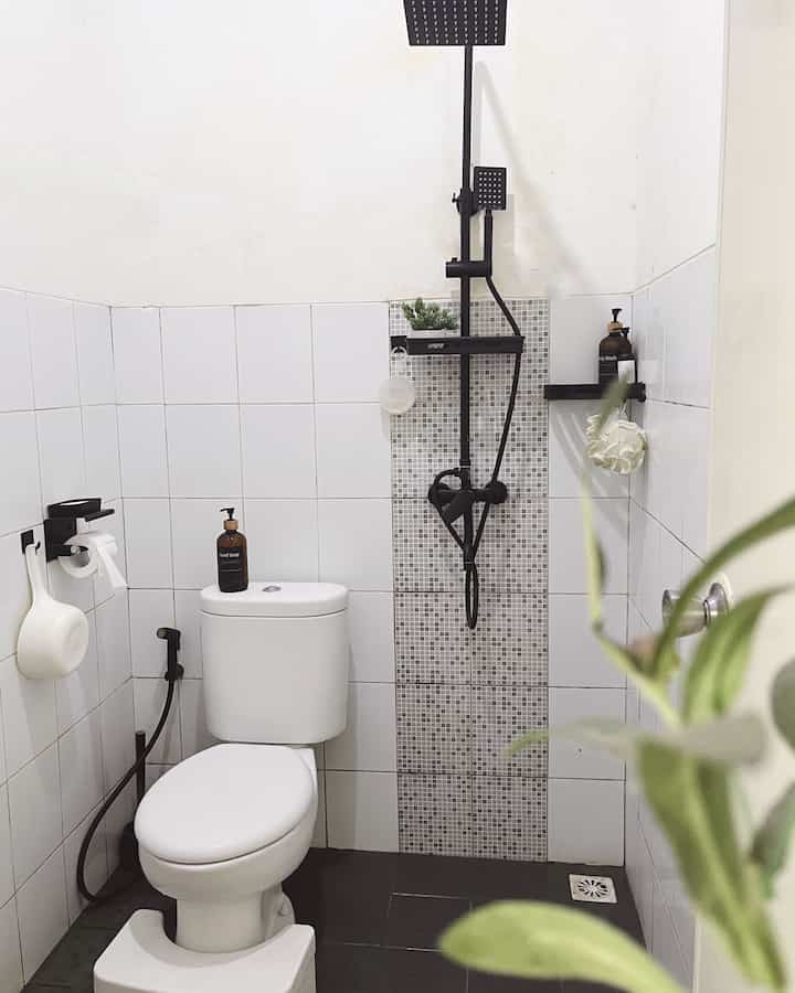 Monotone bathroom in white and black, featuring a sleek black shower set and a clean minimalist layout