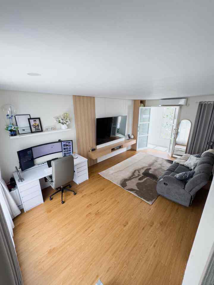 Bright natural color flooring living room combined with a modern home office space featuring sofa and desk