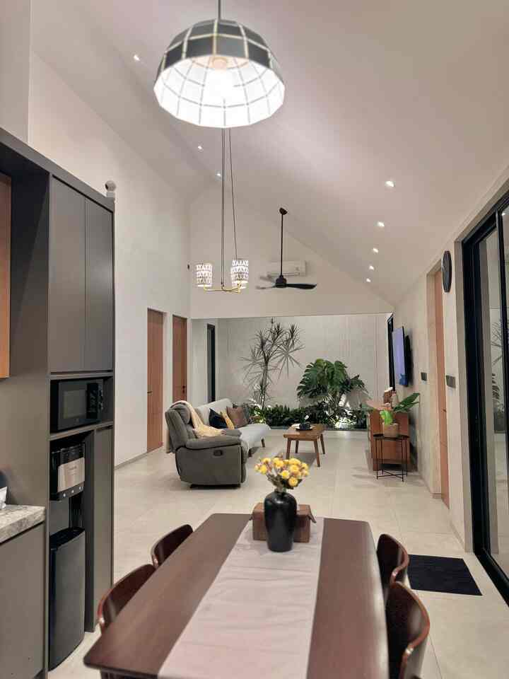 White-walled dining and living room featuring wood-toned furniture with a natural modern cozy atmosphere