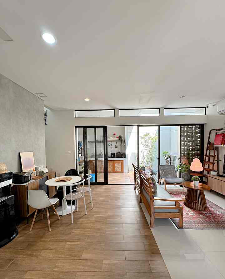 White walls and wood-tone flooring in a two-person household living and dining area separated by sliding glass doors