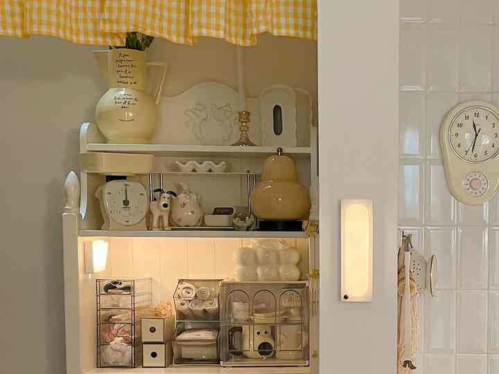Cozy ivory-toned kitchen space featuring vintage decor, storage racks, and wall sconces with warm ambience