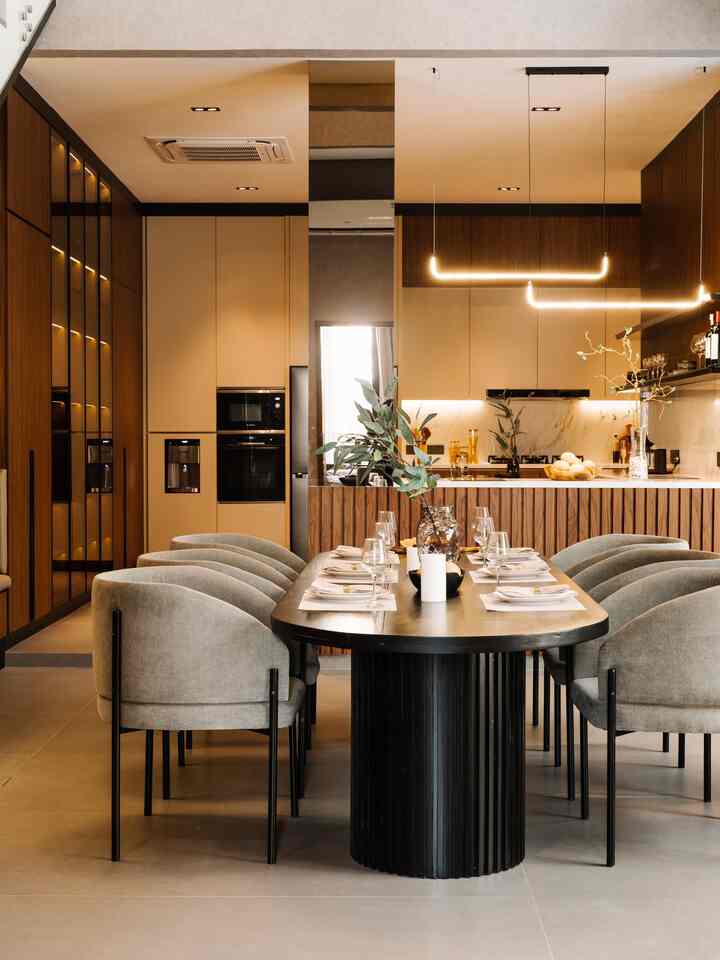 Ruangan ini merupakan contoh desain open space yang elegan dan modern, memadukan area dapur dan ruang makan secara seamless tanpa sekat. Konsep ini memberikan kesan luas, terang, dan nyaman, cocok untuk hunian masa kini yang mengutamakan efisiensi ruang.
	1.	Desain Dapur
Bagian dapur memiliki kabinet bergaya minimalis dengan warna netral seperti krem dan kayu cokelat gelap, menciptakan nuansa hangat sekaligus modern. Sentuhan backsplash marmer menambahkan kesan mewah, sementara pencahayaan tersembunyi di kabinet atas memberi suasana hangat dan fungsional.
	2.	Ruang Makan
Area makan dilengkapi meja panjang dengan desain kaki melingkar berwarna hitam, dipadukan dengan kursi berlapis kain abu-abu yang empuk. Penataan ini menampilkan kesan formal namun tetap nyaman untuk berkumpul bersama keluarga atau teman.
	3.	Pencahayaan
Lampu gantung modern dengan bentuk unik menjadi pusat perhatian sekaligus memperkuat estetika ruangan. Sinar lampu kuning hangat membuat suasana lebih intim dan welcoming.
	4.	Keseluruhan Konsep Open Space
Penggabungan kedua area ini tanpa dinding pembatas menciptakan aliran ruang yang lancar dan mempermudah interaksi antar penghuni. Kehadiran elemen dekoratif seperti tanaman dan elemen kayu menambah sentuhan natural di tengah desain modern.

Ruangan ini sangat cocok untuk generasi muda yang menyukai desain minimalis, fungsional, dan tetap estetis.

#kitchenset #hplaica #ovenbosch #microwavebosch #lilinikea #mejamakan #rumahopenspace #rumahtanpasekat