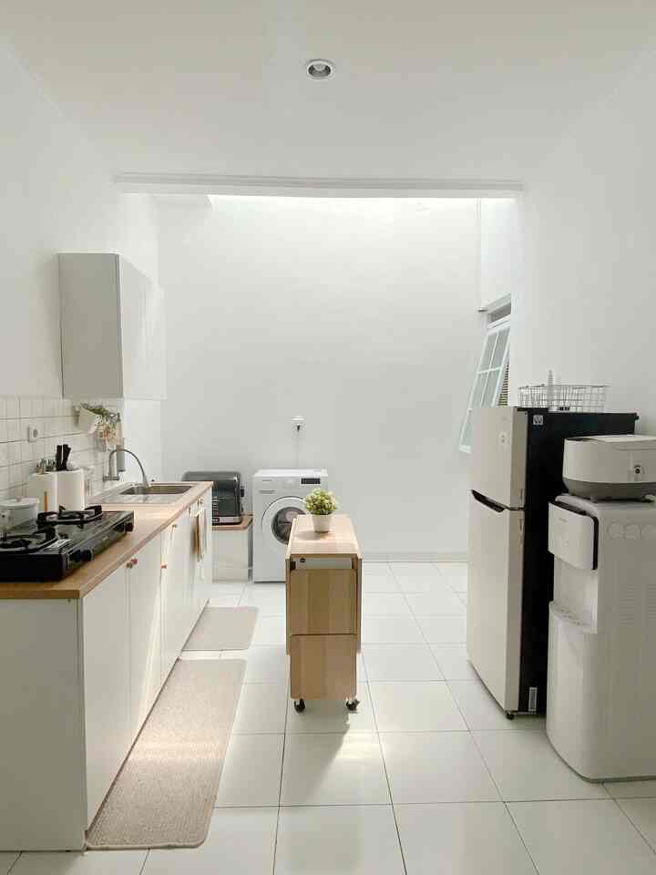 White and wood tone open space kitchen and dining room in a compact, clean layout