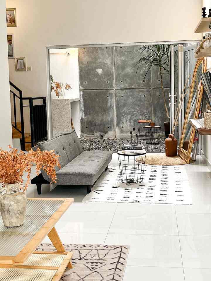 White and gray toned living room featuring a gray sofa bed and round coffee table with modern bright atmosphere