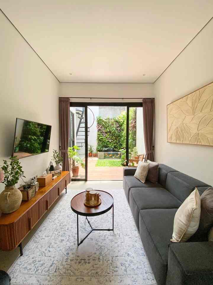 Light gray and wood-tone living room with sliding door and plants, cozy and open atmosphere