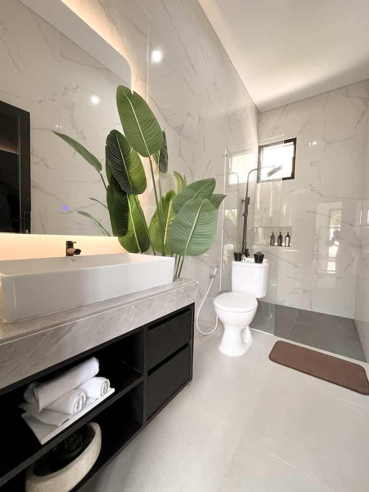 This 1st floor bathroom is next to the living room. 
• 
It has a minimalist feel in line with the bathroom in the main room. 
• 
It has a size of 1.5 x 3.3m so it feels spacious. 

#bathroom #bathroom #inspirasikamarmandi #desainkamarmandi #kamarmandiminimalis #wastafel #cerminled #cermin #closet #closetduduk #tanamanartificial #lantaigranit