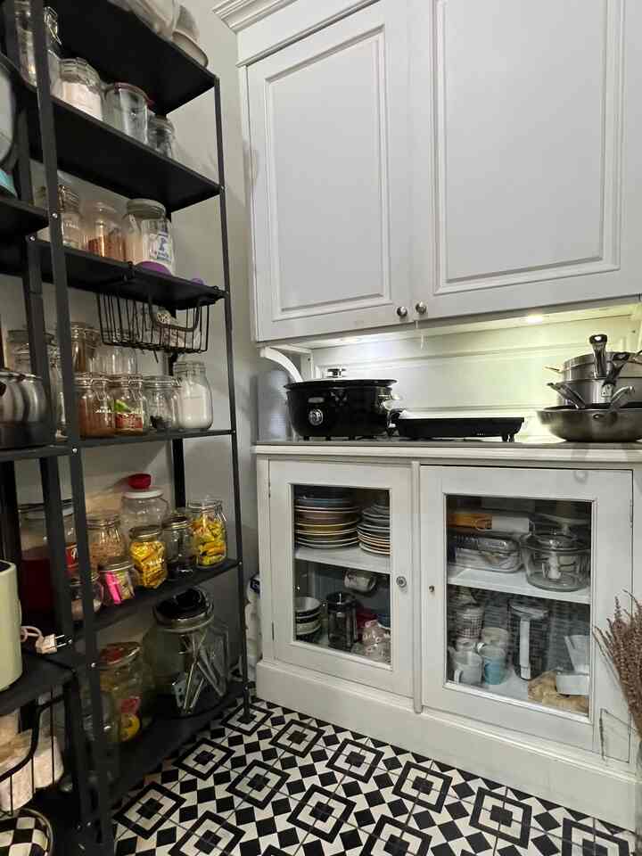 White and black toned kitchen space featuring storage shelves and cookware arranged neatly, creating a practical environment