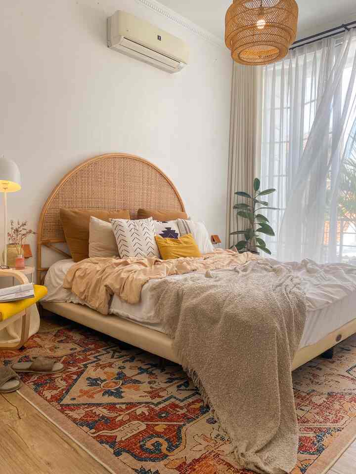 Tips Kamar Nyaman & Aesthetic ✨ 

kamar ini berukuran 3x5 meter, dengan ruang untuk lemari pakaian yang terpisah, jadi ada lebih banyak space untuk menciptakan suasana cozy

ada beberapa tips yang bisa coba diterapkan untuk menciptakan suasana kamar yang gak cuma nyaman tapi juga aesthetic

✨Pilih Palet Warna Hangat
aku menggunakan kombinasi warna netral dengan sentuhan earthy tones, seperti coklat, putih, dan sedikit warna kuning untuk menciptakan suasana tenang namun stylish

✨Tambahkan Elemen Alami
headboard rotan berbentuk arch pada kamar ini menghadirkan nuansa alam yang hangat, menciptakan ruang yang cozy, dan bentuk arch memberikan kesan elegan, 

✨Gunakan Karpet
selain sebagai elemen estetika, karpet juga membuat kamar terasa lebih nyaman untuk bersantai, aku memilih karpet bermotif dengan beragam paduan vibrant colors untuk menambah karakter

✨Tambahkan Dekorasi Personal
untuk dekorasi pada dinding aku tambahkan photo wall decor

✨Cahaya Natural Maksimal
pastikan terdapat bukaan yang cukup di kamar, selain untuk masuknya cahaya juga untuk sirkulasi udara, manfaatkan tirai tipis untuk membiarkan cahaya alami masuk, membuat kamar terasa lebih lapang dan nyaman

✨Area Cozy di Samping Tempat Tidur
salah satu sudut favoritku di kamar adalah area bean bag yang menghadap langsung ke balkon, rasanya tenang apalagi ditemani buku favorit dan udara segar dari luar, benar-benar bikin recharge maksimal

✨Gunakan Dekorasi Sederhana dan Multifungsi
gunakan furnitur minimalis yang tidak makan tempat, seperti meja kecil di samping bean bag, dan standing lamp multifungsi, juga sentuhan tanaman di sudut kamar, sehingga kamar tetap nyaman dan juga leluasa

dengan pemilihan furnitur yang sesuai dan sedikit kreativitas, ukuran kamar berapa pun bisa jadi ruang impian ✨

#Headboard
#HeadboardRotan
#WarnaCatRumah
#Vitrase
#TiraiJendela
#LampuGantung
#Karpet
#KarpetAbstrak
#TanamanHias
#BedCoverPolos
#ThrowBlanket
#BedroomStyling
#InspirasiKamar