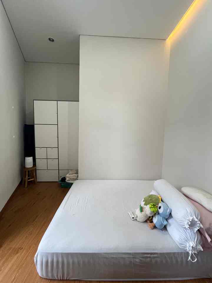 White and brown toned small bedroom with compact wardrobe and simple bed, featuring a natural and cozy atmosphere