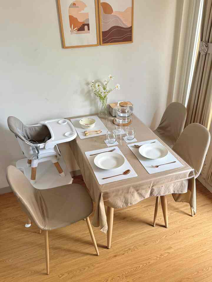 Beige and wood tone dining room featuring a warm, natural dining setup including a baby high chair