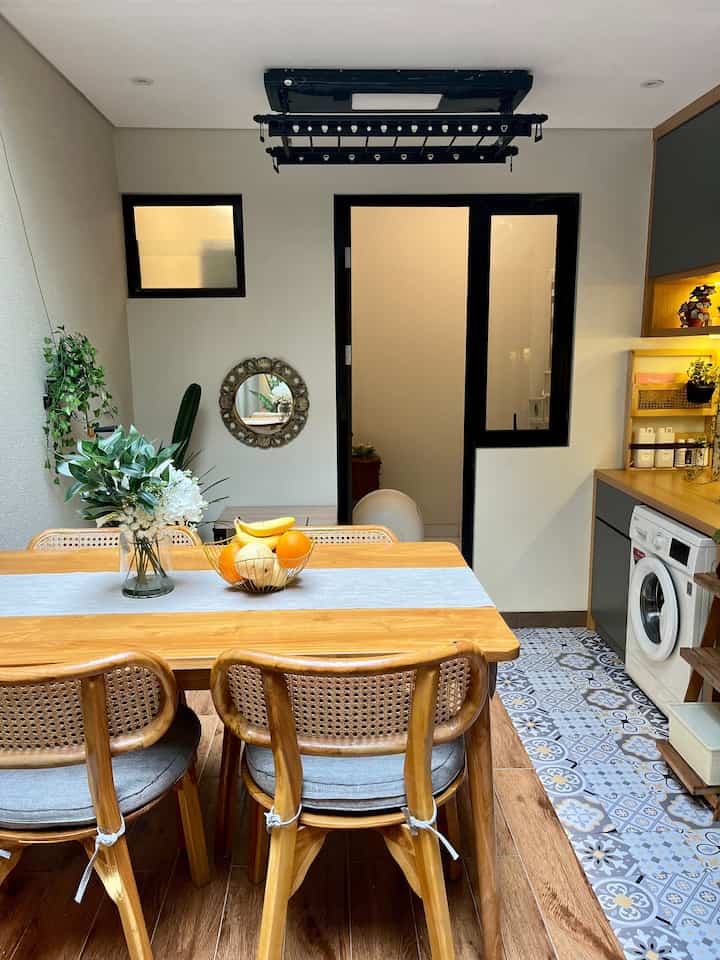Wood-toned dining room with gold accents, featuring a dining table, chairs, and plant decor creating a cozy atmosphere
