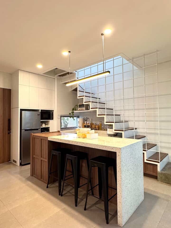 Karena ingin mempunyai ruangan yang compact kami tidak ingin mempunyai banyak area yang terpisah, dengan konsep open space kami menyatukan area kitchen, dining room dan living room. 

Untuk area kitchen dan dining room Meja island ini menjadi area memasak dan kami jadikan juga area makan. Dengan meja yang cukup besar bisa menampung sampai 8 orang untuk makan bersama di meja ini.

#kitchenset #mejaisland #terrazzo #hpltaco #kitchensetminimalis #lampugantung #kursibar #DapurOpenSpace #RumahTanpaSekat
