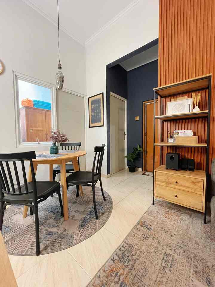 A dining room with white and navy walls featuring a wooden dining table and black chairs, creating a cozy atmosphere