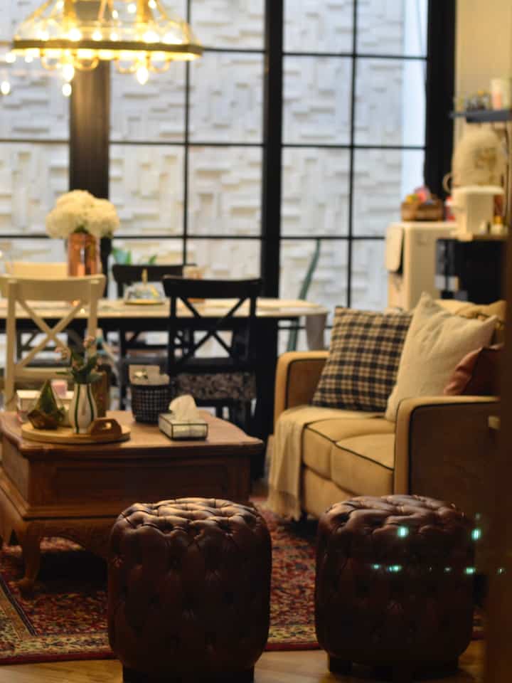 Wood tone and beige living room featuring sofa, armchair, coffee table, and rug creating a warm atmosphere