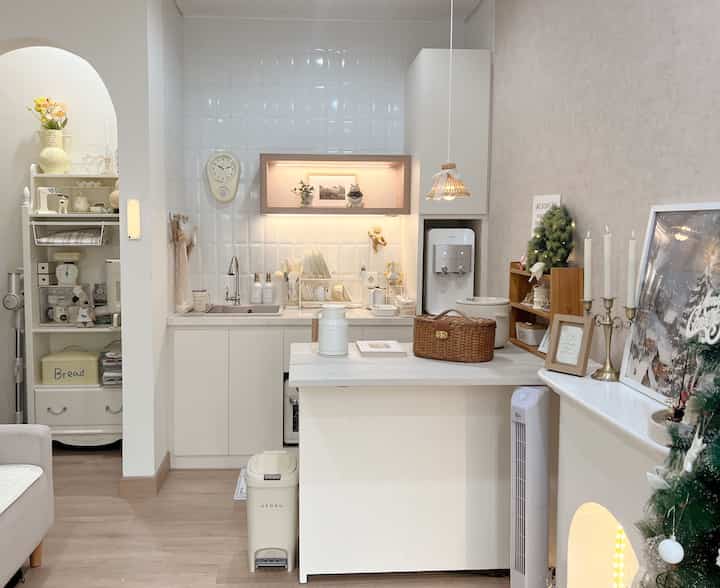 Natural-toned small kitchen and living area featuring a white kitchen island and sofa in a cozy interior