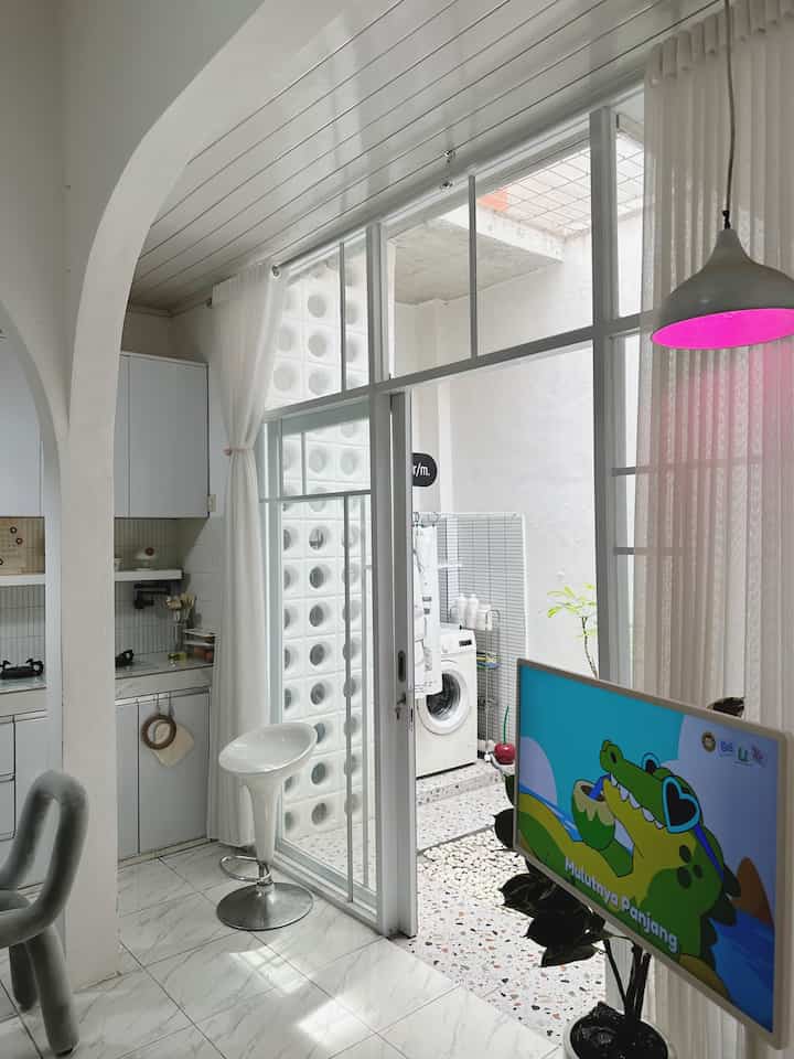 Bright white-toned kitchen space connected to a balcony, featuring a pendant light and curtains with a clean and modern interior