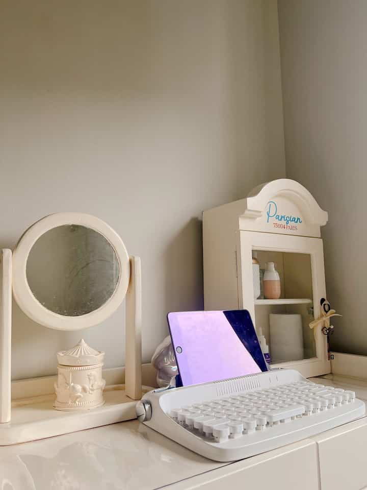 Ivory-toned simple desk space featuring a retro keyboard and iPad in a minimal home office interior