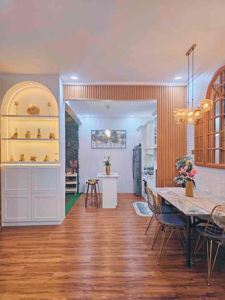Warm wood-tone floor and gold accents in an open plan dining room and kitchen space