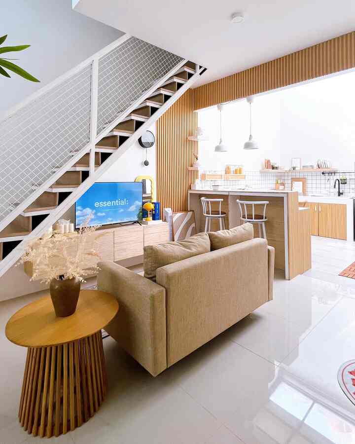 Bright white walls with wood tone furniture creating a cozy natural-style living room and kitchen integration