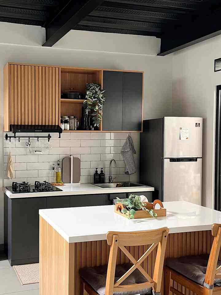 Modern kitchen with harmonious white, black, and wood tones, featuring an island table and wooden chairs in a clean space