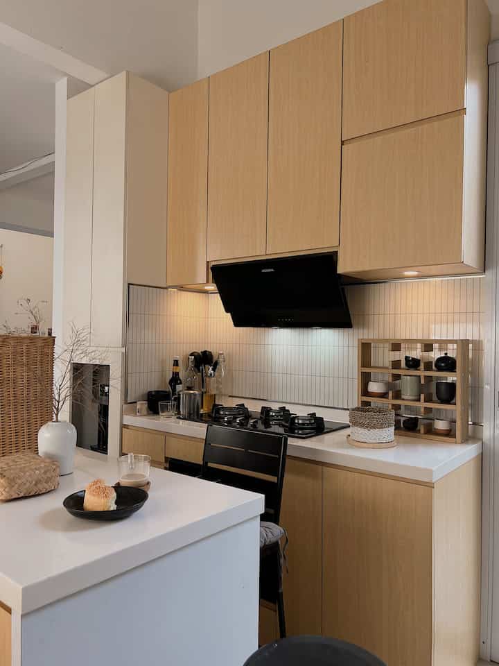 White and wood-tone Japandi kitchen featuring minimal storage ideas in an open space layout