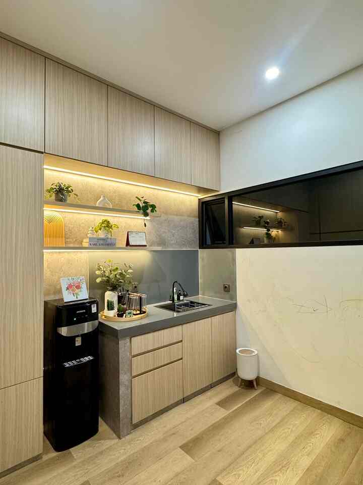 
Pantry minimalis dengan sentuhan semi-industrial yang terlihat rapi dan modern. Kabinet atas dan bawah dilapisi finishing motif kayu yang hangat, memberikan kesan natural sekaligus elegan. Dinding backsplash menggunakan material solid surface dengan warna abu-abu yang selaras dengan countertop beton, menambah kesan industrial. Rak dinding terbuka yang dilengkapi pencahayaan LED digunakan untuk memajang dekorasi seperti pot tanaman kecil dan vas, membuat dapur terasa lebih hidup.

Area wastafel terlihat praktis dan bersih, sementara dispenser hitam di samping kabinet bawah memberikan fungsi tambahan tanpa mengganggu estetika ruangan. Lantai SPC berwarna kayu melengkapi suasana dapur, menciptakan harmoni antara elemen minimalis dan natural. Ruang ini tidak hanya estetik, tetapi juga fungsional.

#pantry #lantaispc #solidsurface #kabinettinggi #DapurMinimalis
#InteriorDesign
#HomeDecor
#InspirasiRumah
#RuangFungsional
#DekorasiEstetik