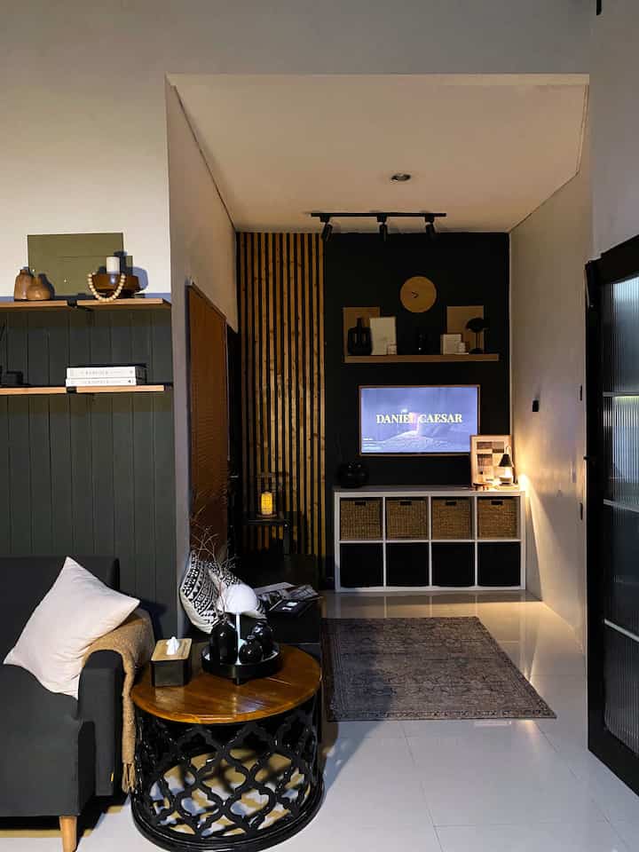 ➖ Our Living Room in Nite Vibes ✨

Ruang tamu dan ruang keluarga mungil ini, kami tata agar tetap terlihat agak luas dan compact.

Menggabungkan kekuatan hitam bold dengan kelembutan kayu dan rotan—ruang keluarga kecil ini jadi tempat sempurna untuk bersantai.

#Catdinding #CoffeeTable #GranitLantai #Sofa2Seater #KarpetEtnik #KarpetBoho #CandleWarmer #Cushions #TVLed #SlatWall #Ambalankayu #Vas #CompactLivingRoom #Ruangkeluarga #RuangTV #RuangTamu #livingroom #inspirasiruangkeluarga #inspirasiruangtv #dekorasiruangkeluarga #livingroomdecor #CozyCorner #MinimalistHome #RuanganTerbatas
#LivingRoomMungil #NightVibe 