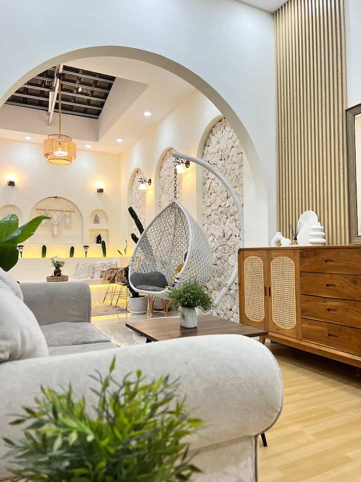 Ruang tamu ini open space tanpa sekat yang menyambung ke area ruang santai dan musholla. Ukuran ruang tamu ini 3x6meter dengan konsep japandi style. Sedangkan untuk ruang santai dengan konsep villa ala bali dengan adanya sentuhan limestone dan nuansa arch wall ditambah lighting yang membuat suasana semakin cozy.
#livingroom #musholla #archwall #sofaminimalis #RumahOpenSpace #RumahTanpaSekat #NightVibe 