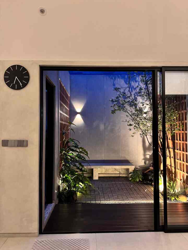 Wood tone and gray-walled balcony space with black framing elements, presenting a modern and sleek atmosphere
