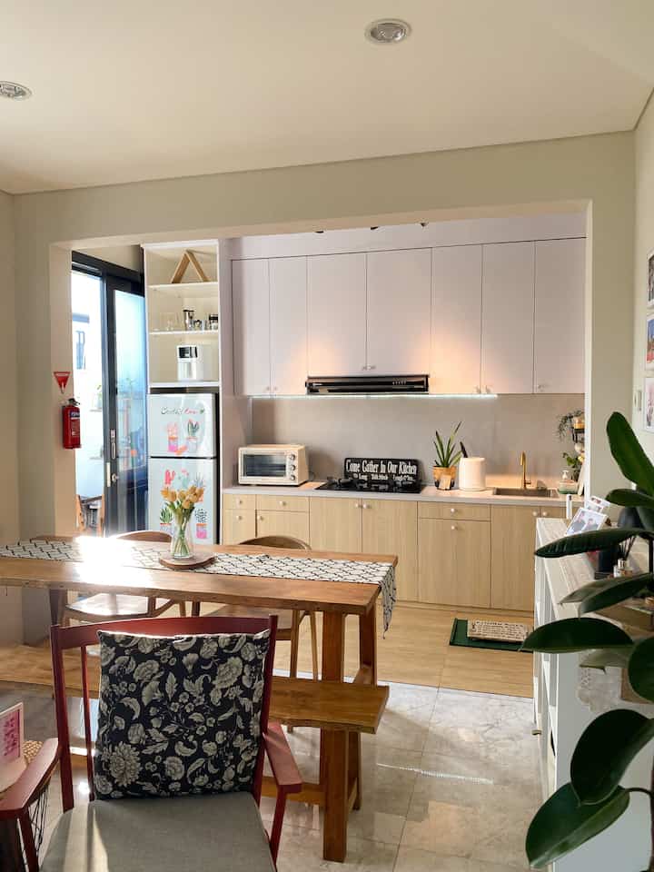 Natural wood tone and white kitchen with dining table creating a simple and functional space