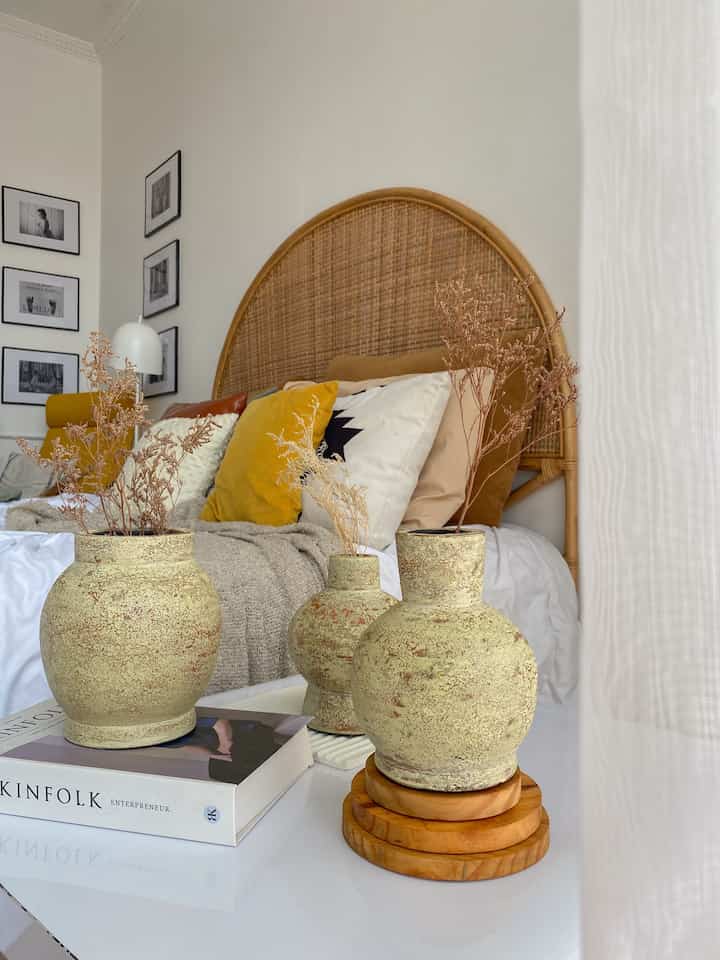 Menghadirkan Nuansa Earthy di Kamar Scandi-Boho dengan Vas Dekorasi

Pilih Vas dengan Tekstur Alami
Untuk menambahkan nuansa earthy, pilih vas dengan bahan atau tekstur yang berkesan alami, seperti keramik berwarna tanah, batu, atau dengan finishing matte. Vas seperti ini langsung memberi kesan rustic yang khas.

Gunakan Warna Earthy
Pastikan warna vas selaras dengan palet earthy seperti beige, terracotta, cokelat muda, atau abu-abu hangat. Warna-warna ini menambah kesan hangat tanpa mengganggu elemen scandi yang minimalis.

Isi dengan Elemen Natural
Tambahkan dried flowers, elemen ini menciptakan kesan boho yang effortless sekaligus memperkuat gaya earthy dengan tekstur dan warna alami.

Susun Vas Secara Dinamis
Jika menggunakan beberapa vas, susun dengan ketinggian yang berbeda. Atur dalam formasi segitiga atau tumpuk di atas buku dekorasi untuk menciptakan visual yang menarik dan seimbang.

Letakkan di Area Strategis
Vas bisa diletakkan di atas meja samping tempat tidur, di rak dinding, atau bahkan di sudut ruangan. Letakkan di area yang sering terlihat untuk menjadi focal point ruangan.

Tambahkan Elemen Pelengkap
Kombinasikan vas dengan aksesori lain seperti tatakan kayu untuk memperkuat tema earthy tanpa membuat ruangan terasa terlalu ramai.

Jaga Keseimbangan dengan Gaya Scandi
Pastikan vas dan isinya tetap sederhana sehingga tidak “bertabrakan” dengan estetika kamar yang tenang.

Dengan menambahkan vas dekorasi yang tepat, kamu bisa menciptakan nuansa earthy yang hangat sekaligus memperkuat tema scandi-boho di kamar. Sentuhan kecil seperti ini memberikan perubahan besar tanpa perlu renovasi besar-besaran!

#WarnaCatDinding
#VasDekorasi
#HeadboardRotan
#ScandiBohoStyle
#BohoStyle
#EarthyBoho
#DekorasiKamar