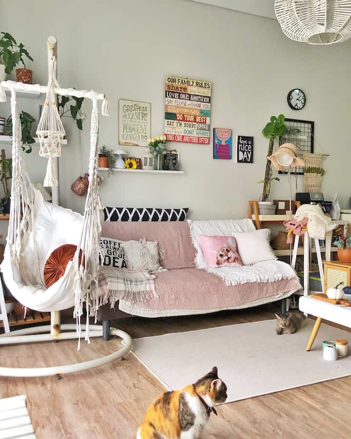 Cozy Scandinavian living room in white and light brown tones featuring bohemian elements and a home office setup