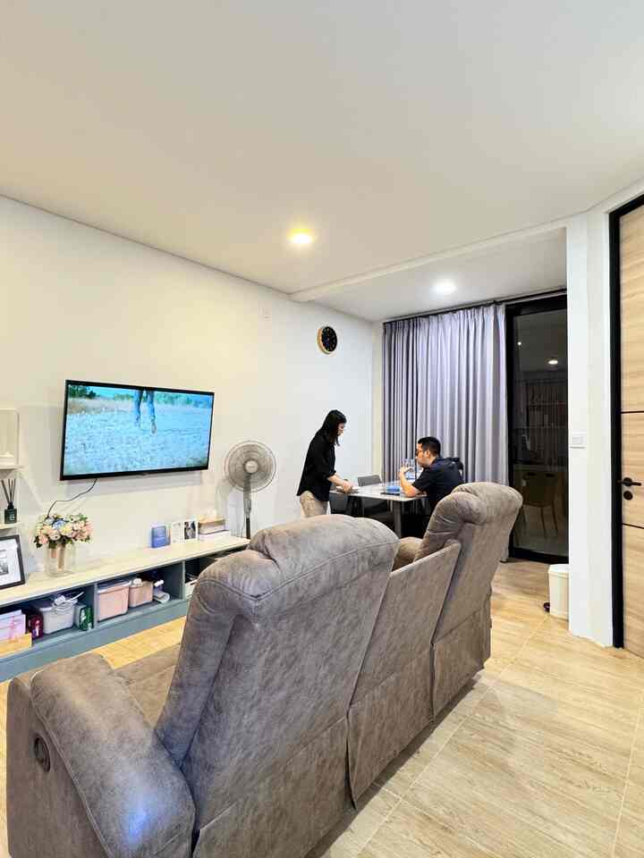 Bright white-walled living room with gray recliner sofa and dining table near window with curtains, neat and modern atmosphere