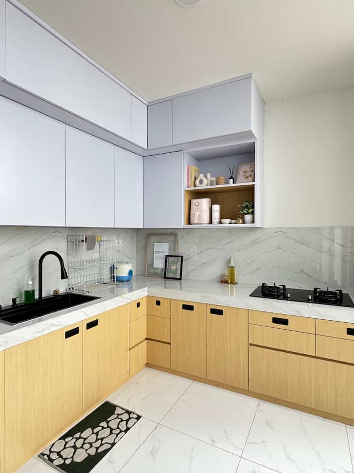 Kitchen renovation process of livin's home.

When this house was handed over from the developer, this kitchen area was not there at all.

Previously I shared a glass door that leads to the kitchen, which is adjacent to the dining room. This is the first renovation process, so I moved the glass door back so that there was space for the dining room (slide 2).
The length of this house was initially only up to the sofa (slide 5).

In slides 3 & 4, this is the initial view of the kitchen which is in the living room area which I then renovated and built a kitchen on the remaining land behind. I divided the remaining land into 2 to build a kitchen and garden, the concept of this kitchen is semi-outdoor slide 6 & 7). I installed a sliding door that leads to the garden, so I can open and close the door and the air circulation in the kitchen remains good.

This kitchen set uses HPL with a combination of Natural Wood and White. Because I want it to look clean. I also customized a full kitchen set so that I can store items that are rarely used, so I utilize all the available space.

I use granite tiles on the floor in my kitchen area, because it is easier to clean than the matte ones.

#livinshome #KitchenSet #KitchenSetMinimalis #KitchenRenovation #MyDreamKitchen #KitchenStyling