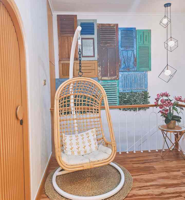 Natural tone living room featuring a rattan armchair and colorful wall decor in a cozy atmosphere