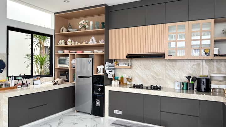 A clean U-shaped kitchen in white and dark gray tones featuring natural wood shelving and modern kitchen appliances in harmony