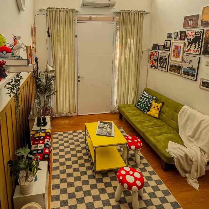 Yellow and green toned living room featuring a yellow coffee table, green sofa, and wall art for a cozy atmosphere