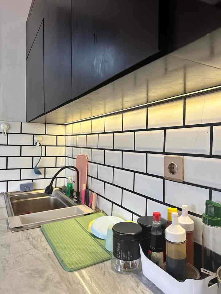 White and black toned kitchen featuring sink and neatly arranged cooking tools in a functional space