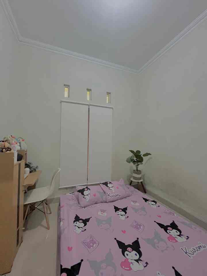 Kids' room with soft pink bedspread featuring Kuromi characters, white walls and blinds creating a cozy vibe